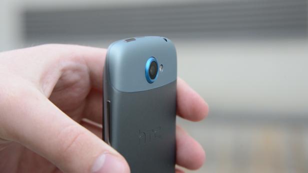 Die Rückseite eines HTC-Smartphones wird von einer Hand gehalten.