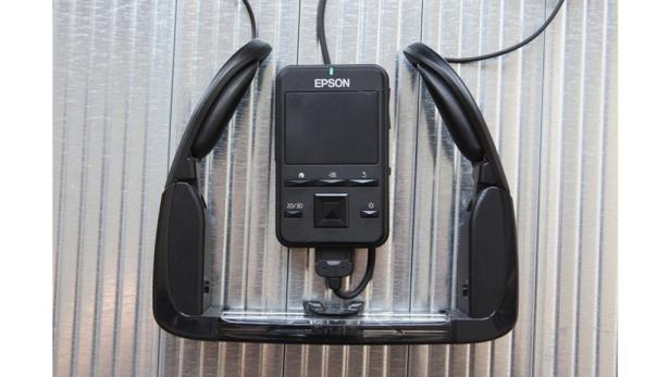 Eine Epson Moverio Brille mit Controller vor einem metallischen Hintergrund.