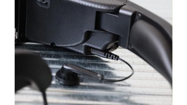 Ein schwarzer Kopfhörer ist an ein Gerät angeschlossen.