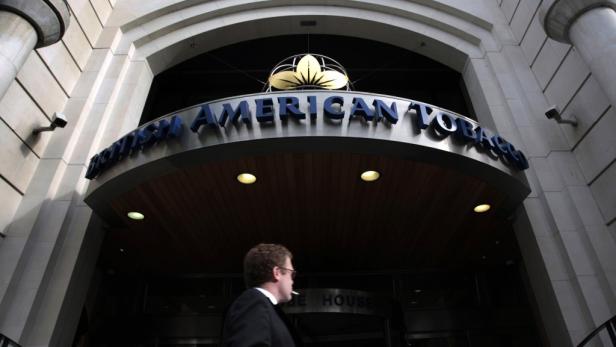 Ein Mann mit Zigarette vor dem Gebäude von British American Tobacco.