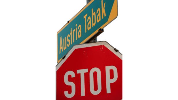 Ein Stoppschild unter einem Schild, das auf Austria Tabak hinweist.
