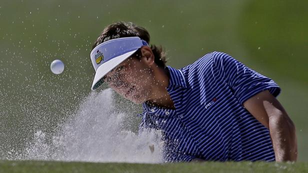 Ein Golfspieler schlägt einen Ball aus einem Sandbunker.