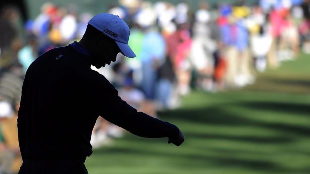 Die Silhouette eines Golfspielers mit Kappe auf einem Golfplatz.