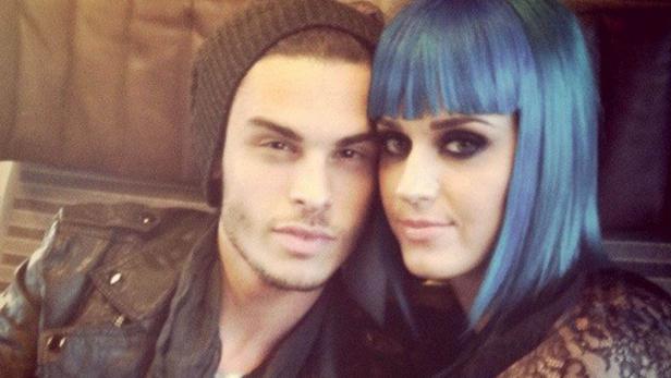 Ein Mann mit Mütze und eine Frau mit blauen Haaren posieren für ein Selfie.