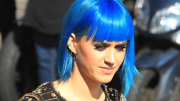 Eine Frau mit blau gefärbten Haaren und dunklem Augen-Make-up.