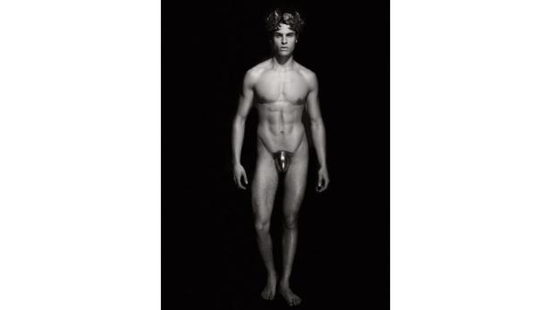 Ein Mann mit Lorbeerkran trägt einen metallischen Penis Köcher.