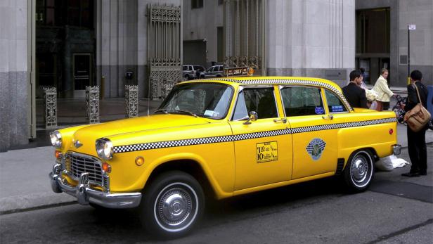 Ein gelbes Taxi steht in einer Straße in New York.