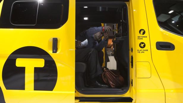 Ein Mann arbeitet im Inneren eines gelben Taxis.