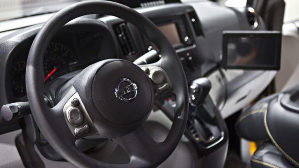 Das Interieur eines Nissan-Fahrzeugs mit Fokus auf das Lenkrad und das Armaturenbrett.