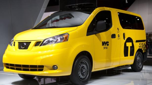 Ein gelbes Taxi der Marke Nissan steht auf einer Ausstellung.