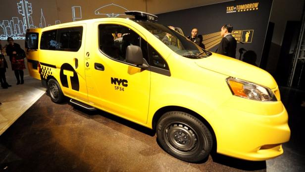 Ein gelbes Taxi der Zukunft von Nissan steht auf einer Ausstellung.