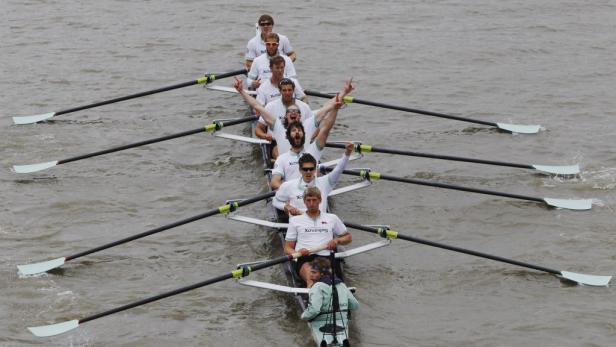 Ein Achter-Ruderteam feiert seinen Sieg auf dem Wasser.