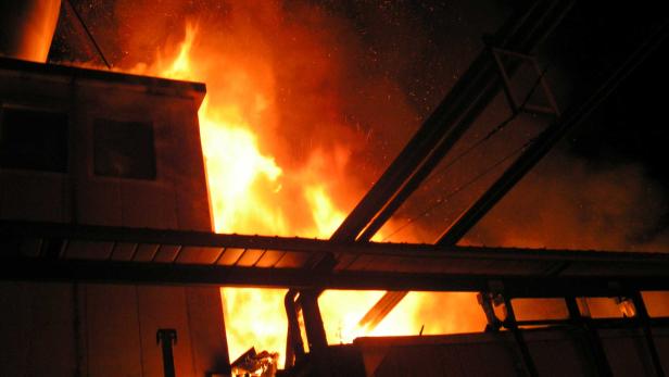 Ein Gebäude steht in Flammen, Rauch steigt auf.