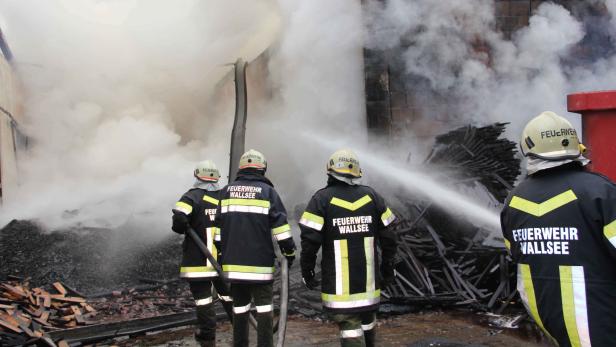 Feuerwehrleute bekämpfen einen Brand in einem Gebäude in Wallsee.