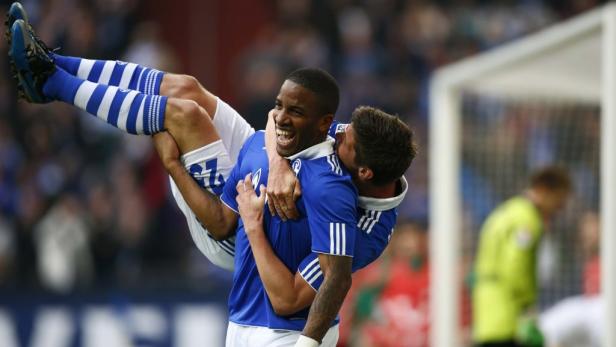 Zwei Fußballspieler in blauen Trikots feiern ein Tor.