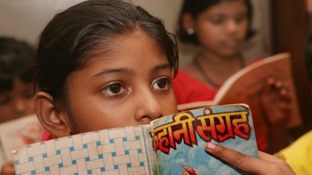 Ein junges Mädchen liest ein Buch mit dem Titel „कहानी संग्रह“.