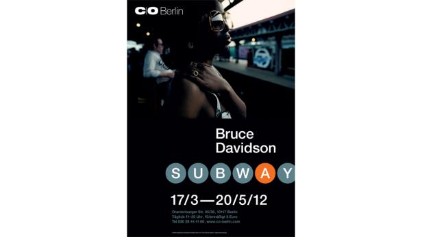 Eine Frau mit Sonnenbrille wartet an einer U-Bahnstation in Berlin.