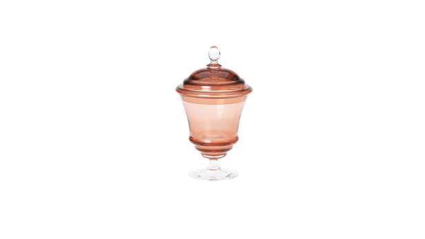 Ein rosafarbenes Bonbon Glas mit Deckel auf einem weißen Hintergrund.