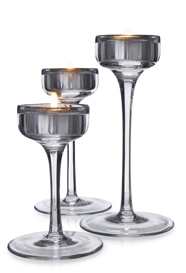 Drei Teelichthalter aus Glas mit brennenden Kerzen.