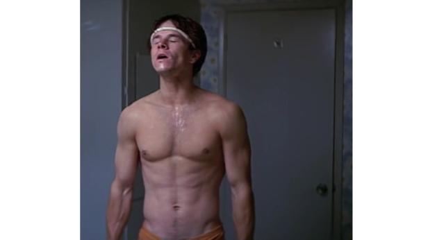 Ein verschwitzter Mark Wahlberg steht mit nacktem Oberkörper in einem Badezimmer.