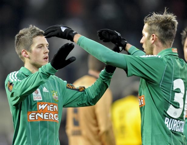 Zwei Fußballspieler in grünen Trikots geben sich ein High-Five.