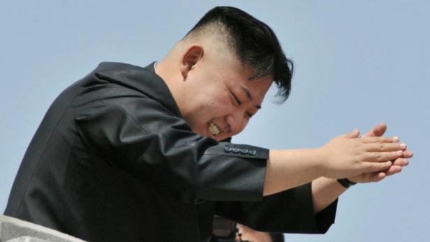 Kim Jong-un klatscht mit einem breiten Lächeln in die Hände.
