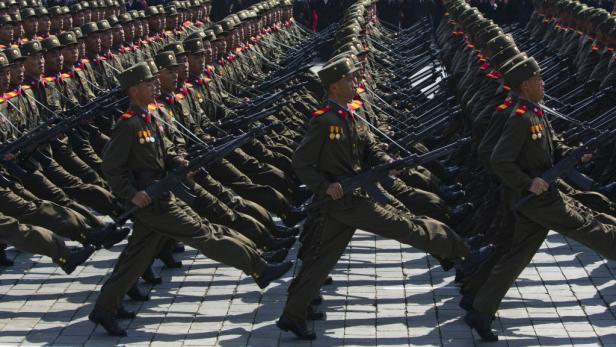 Nordkoreanische Soldaten marschieren in einer Parade mit Gewehren.
