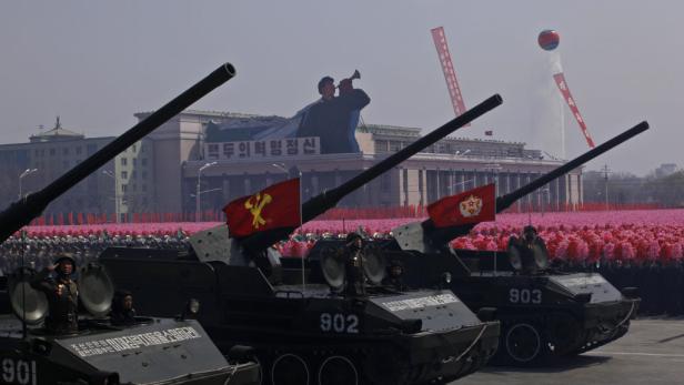 Militärparade in Nordkorea mit Panzern und jubelnder Menschenmenge.