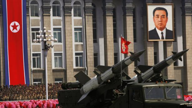 Eine Militärparade in Nordkorea mit Raketenwerfern und einem Porträt von Kim Il-sung.