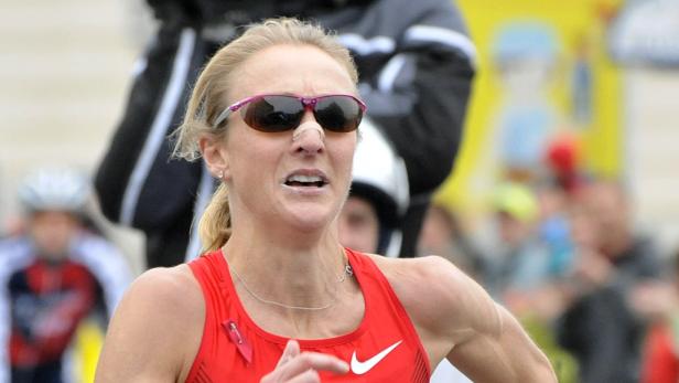 Eine Frau mit Sonnenbrille und Pflaster auf der Nase läuft einen Marathon.