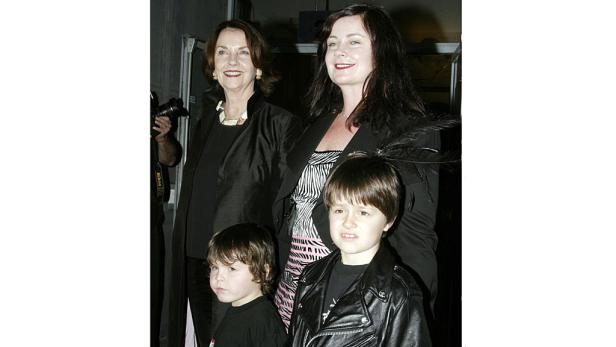 Eine Frau mit zwei Kindern und einer älteren Dame posiert für ein Foto.