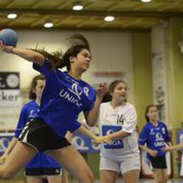 Eine junge Frau wirft einen Handball während eines Spiels.