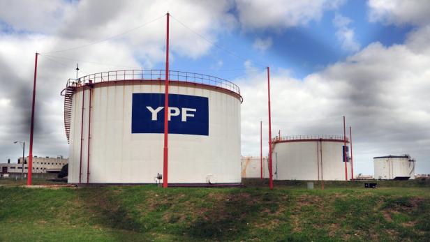 Mehrere weiße Tanks mit dem blauen YPF-Logo auf einem grünen Feld.