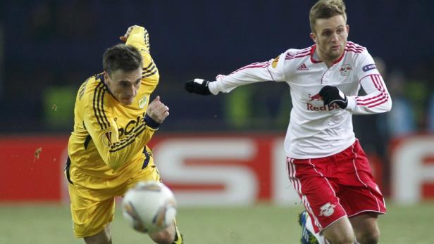 Zwei Fußballspieler kämpfen um den Ball während eines Spiels.