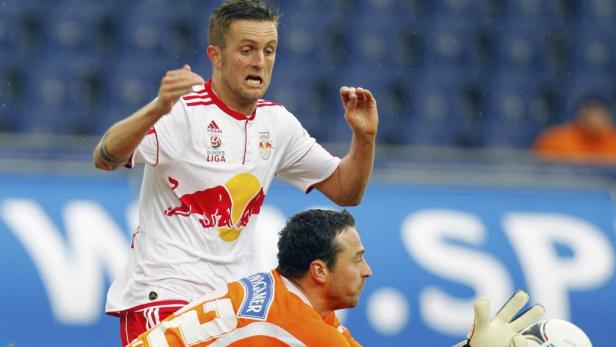 Ein Fußballspieler im Zweikampf mit einem Torwart.