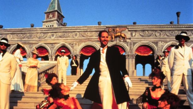 Eine Szene mit elegant gekleideten Menschen vor einem Gebäude im venezianischen Stil.