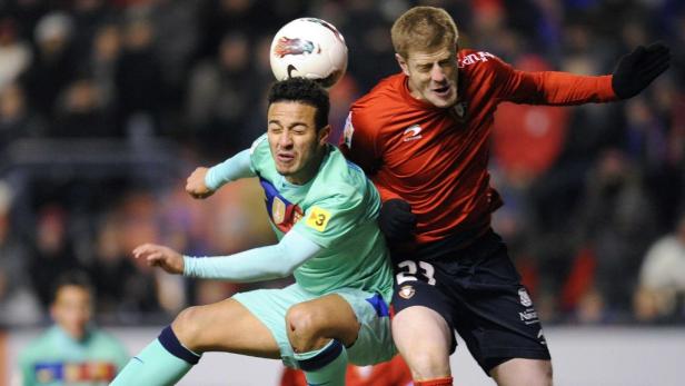 Zwei Fußballspieler kämpfen um den Ball während eines Spiels.