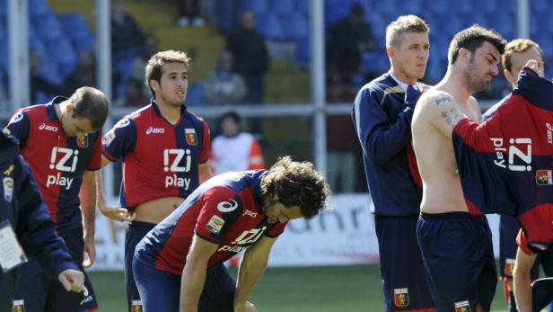 Mehrere Fußballspieler des FC Genua 1893 nach einem Spiel auf dem Rasen.