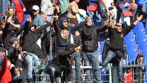 Eine Gruppe von Fußballfans jubelt auf der Tribüne.