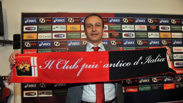 Ein Mann hält einen Schal des Fußballvereins Genua Cricket and Football Club hoch.