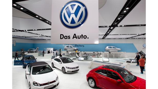 Verschiedene Volkswagen-Modelle auf einer Automobilausstellung unter einem VW-Logo mit dem Slogan „Das Auto.“.