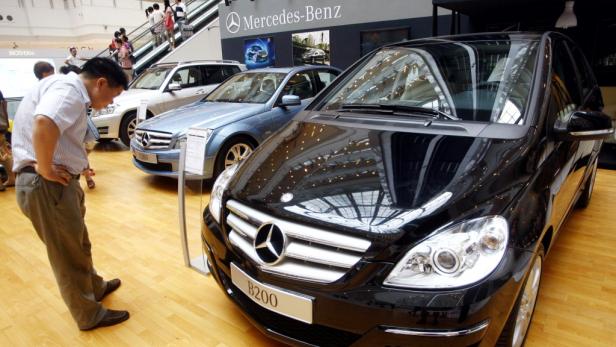 Ein Mann betrachtet einen schwarzen Mercedes-Benz B 200 in einem Ausstellungsraum.