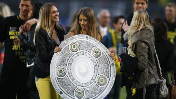 Zwei Frauen halten die Meisterschale der Fußball-Bundesliga.