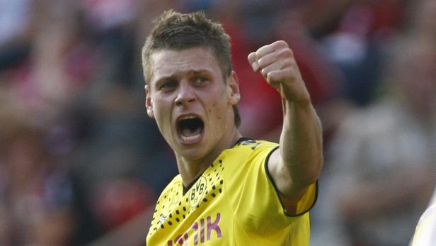 Ein Fußballspieler im gelben Trikot von Borussia Dortmund jubelt mit geballter Faust.