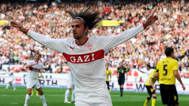 Ein Fußballspieler des VfB Stuttgart jubelt mit ausgestreckten Armen vor einer Zuschauermenge.