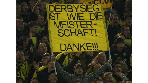 Ein Fan hält ein gelbes Schild mit der Aufschrift „Derbysieg ist wie die Meisterschaft! Danke!!!“.