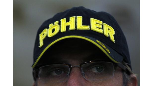 Nahaufnahme einer Person, die eine schwarze Kappe mit der gelben Aufschrift „PÖHLER“ trägt.