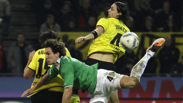 Zwei Fußballspieler kämpfen um den Ball während eines Spiels.