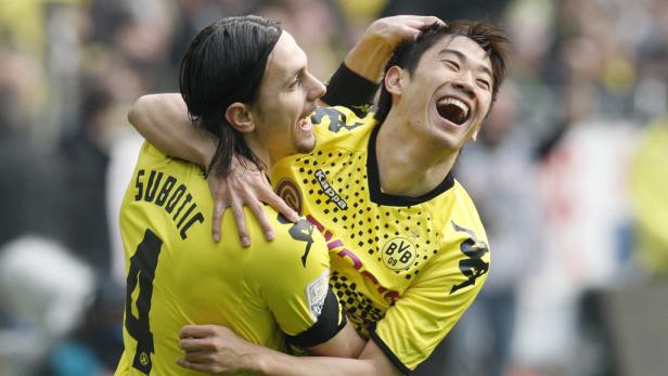 Zwei Fußballspieler von Borussia Dortmund jubeln gemeinsam.