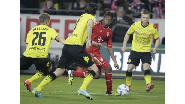 David Alaba (FC Bayern) im Zweikampf mit Spielern von Borussia Dortmund.